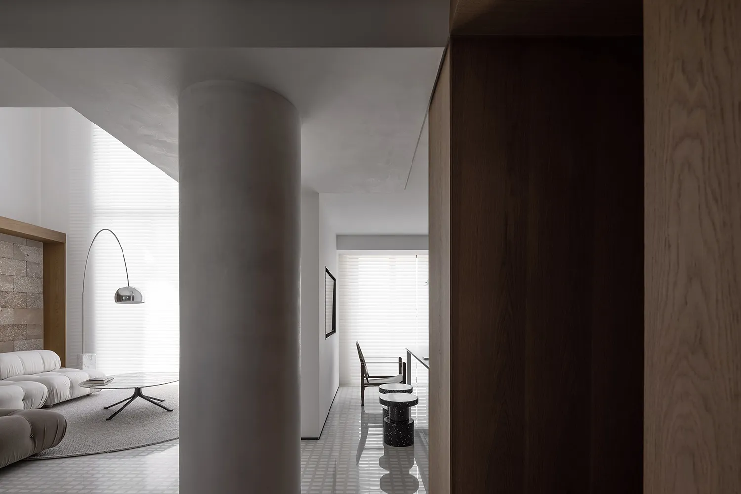 Contemporary living room with white marble finishes, sleek minimalist furniture, and a spacious design.