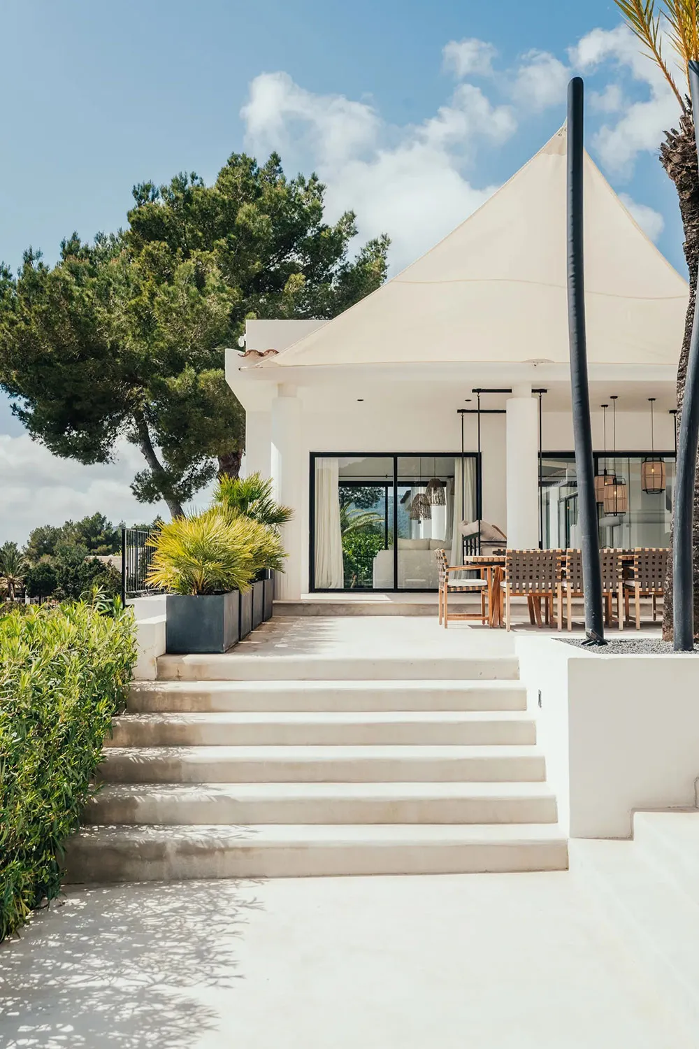 Modern residential exterior featuring minimalist design with concrete, glass, and steel materials.