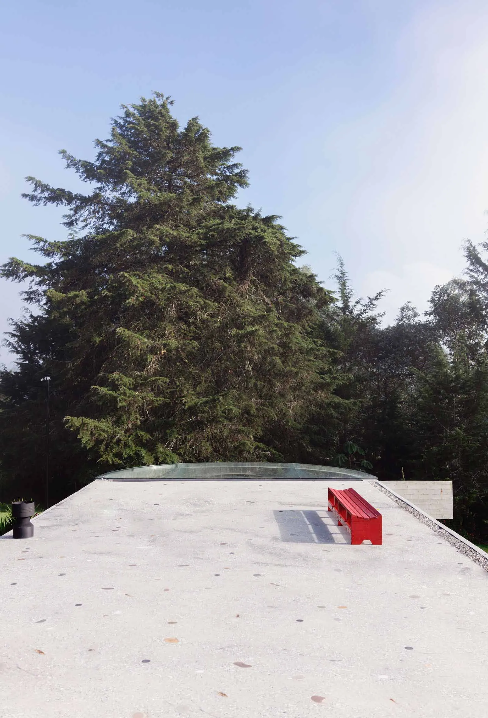 Modern roof deck with red seating area and glass roof