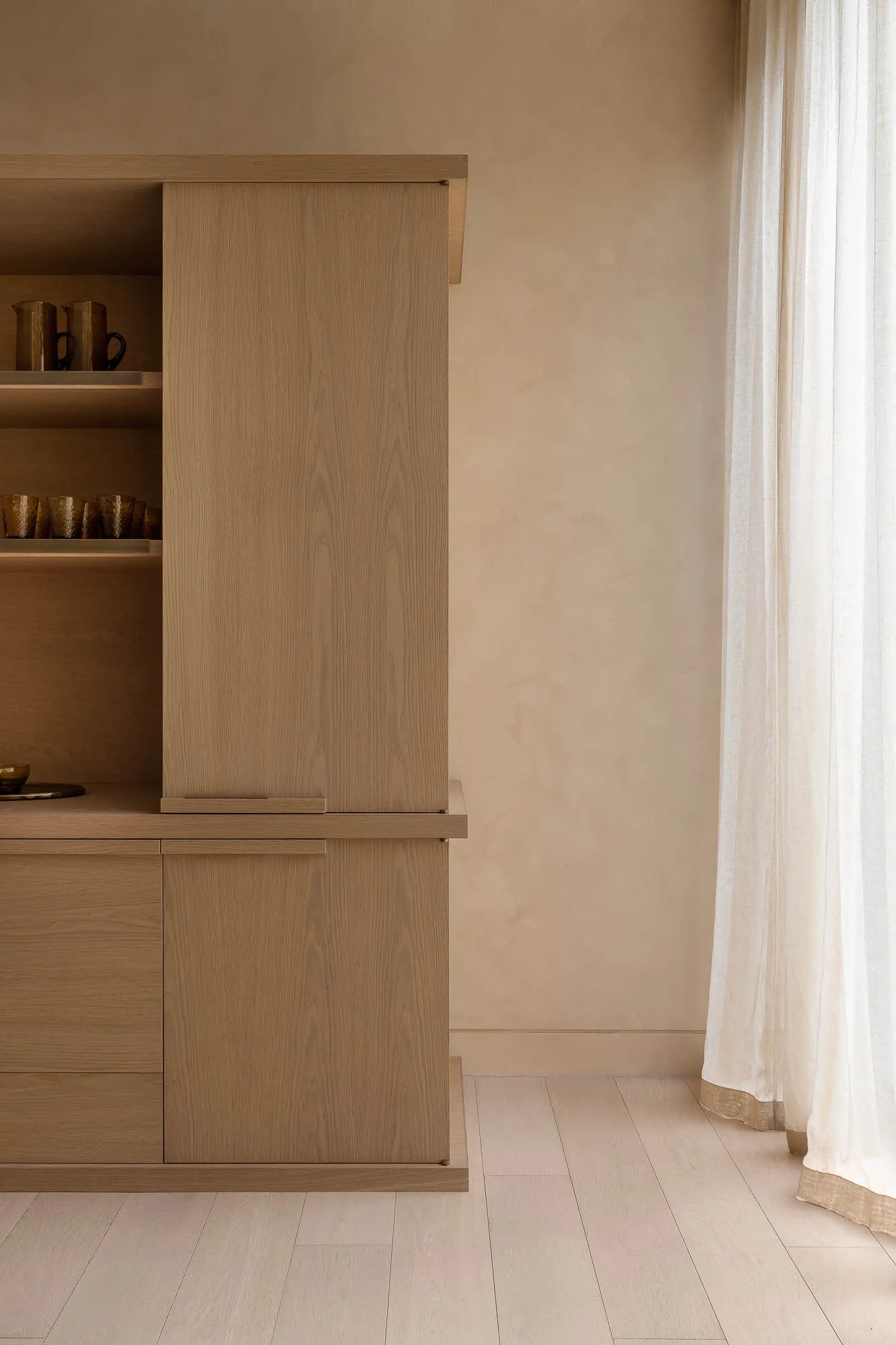A minimalist kitchen storage unit made of wood, featuring sleek lines and simple design.