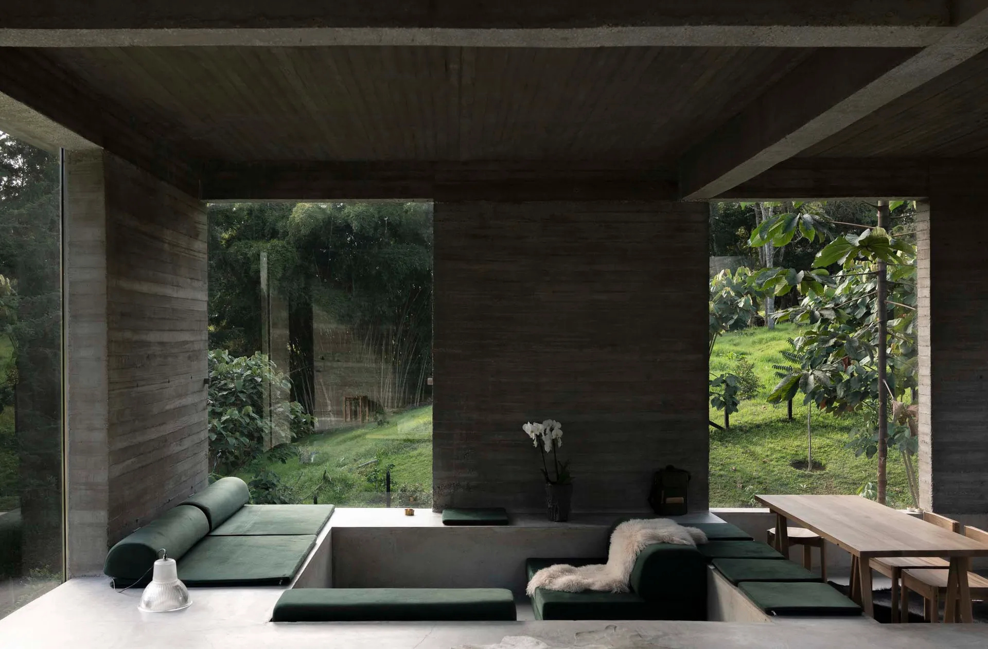 A modern industrial interior design featuring exposed concrete and glass.
