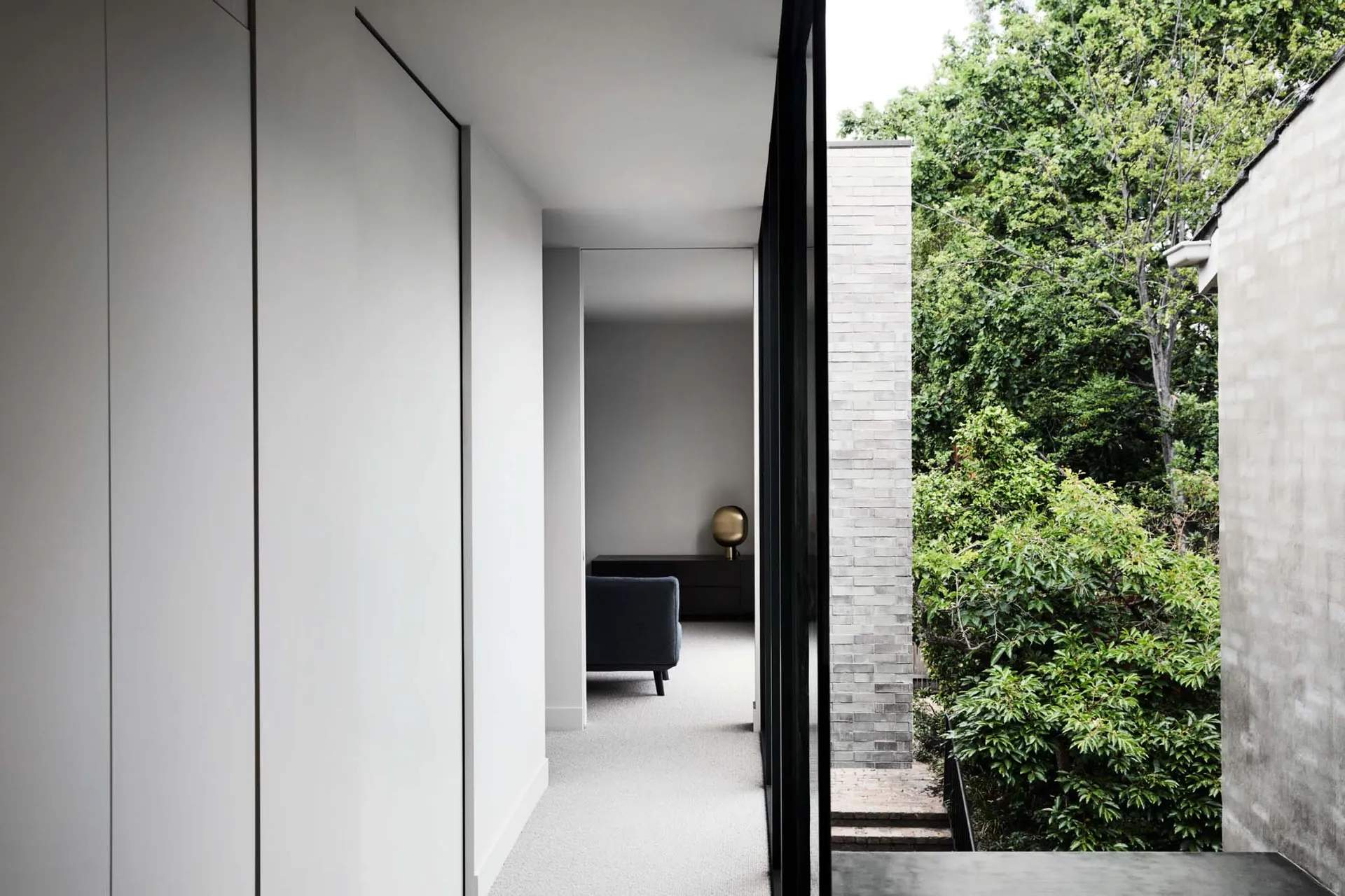 Interior design showcasing modern concrete walls and floor with a large window providing a view of greenery and natural light