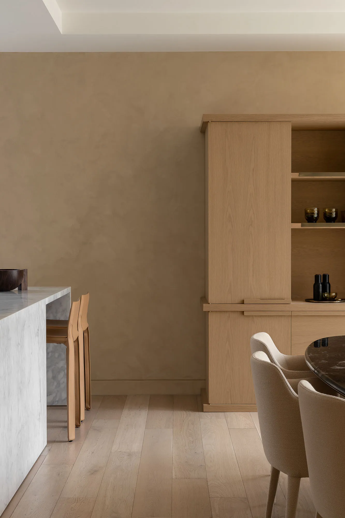 Modern minimalist kitchen and dining area featuring wooden furniture and marble countertop.