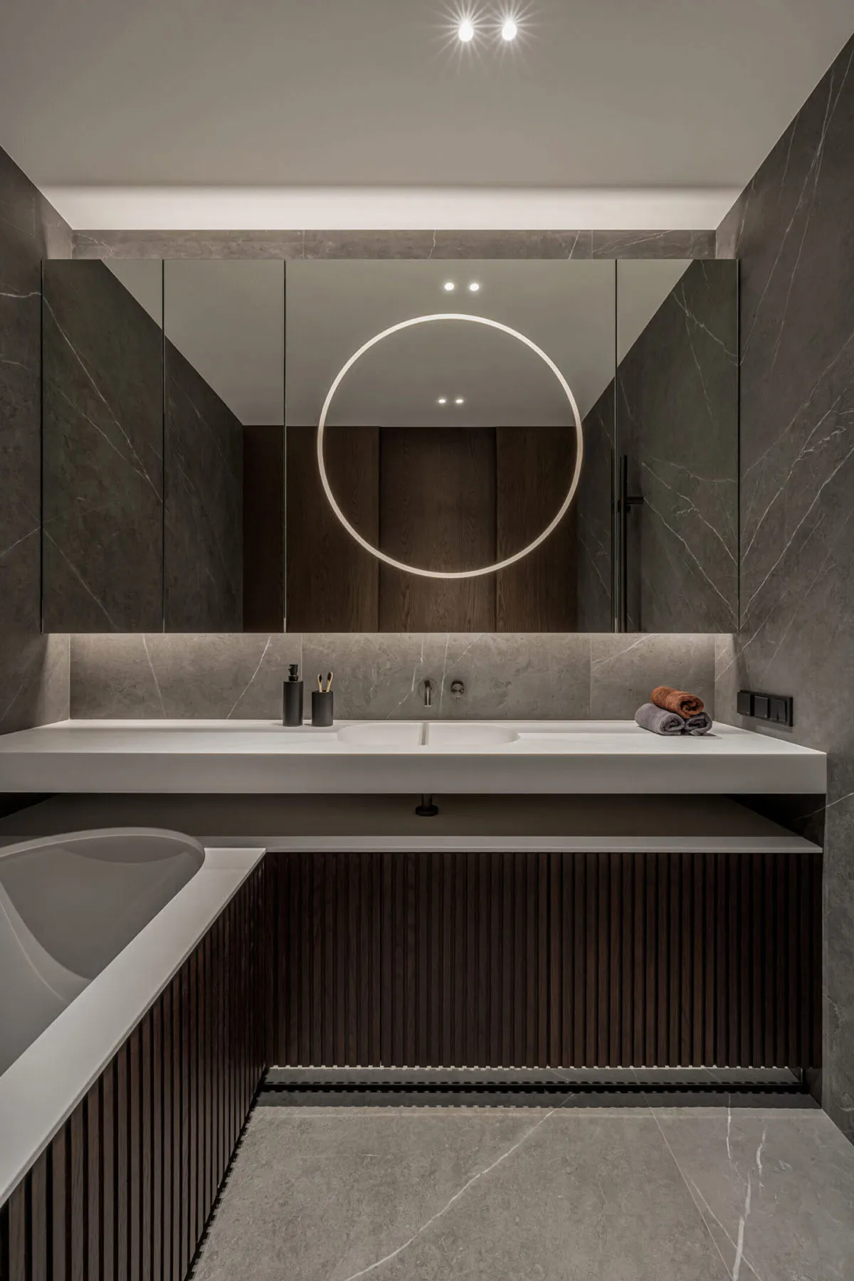Contemporary bathroom with concrete and marble materials, featuring a minimalist design aesthetic.