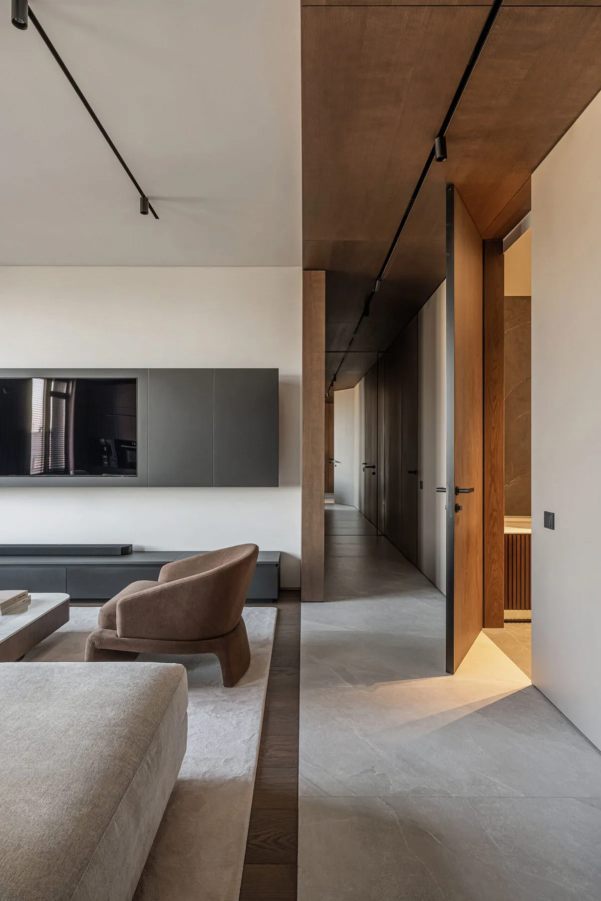 Modern minimalist living room featuring sleek furniture, concrete floor, and laminate surfaces