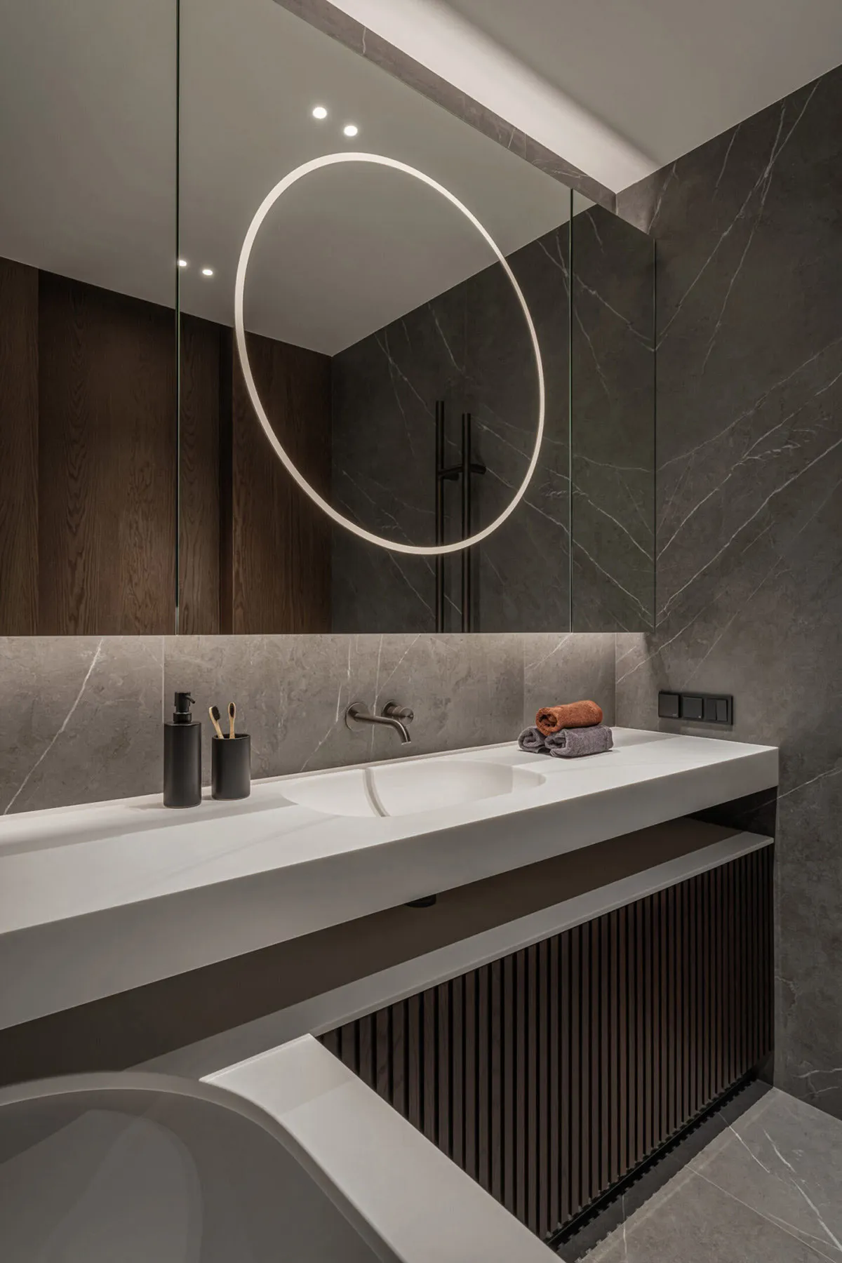 Modern bathroom featuring sleek marble tiles and a contemporary sink design.