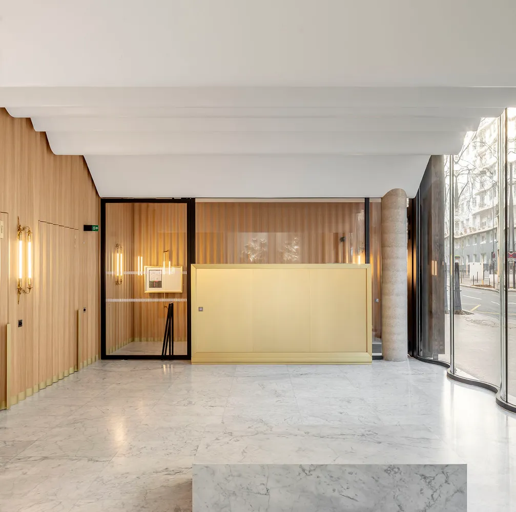 A modern lobby featuring marble finishes and light fixtures.