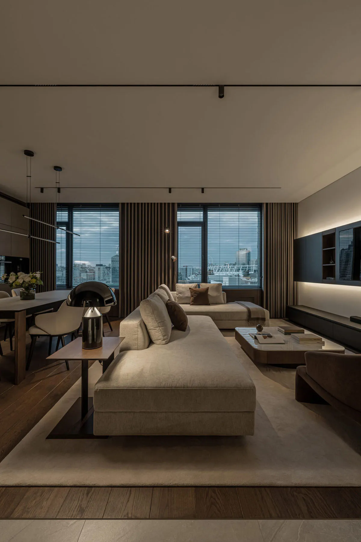 A modern living room featuring fabric sofas, wood flooring, and metal accents.