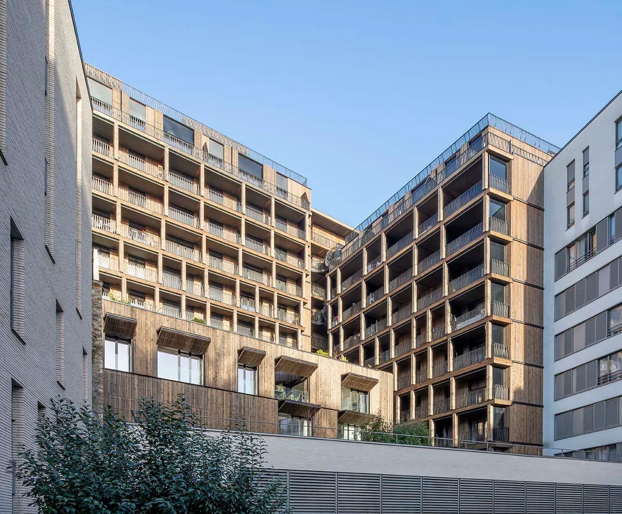 Modern residential building with wooden façade and multiple balconies.