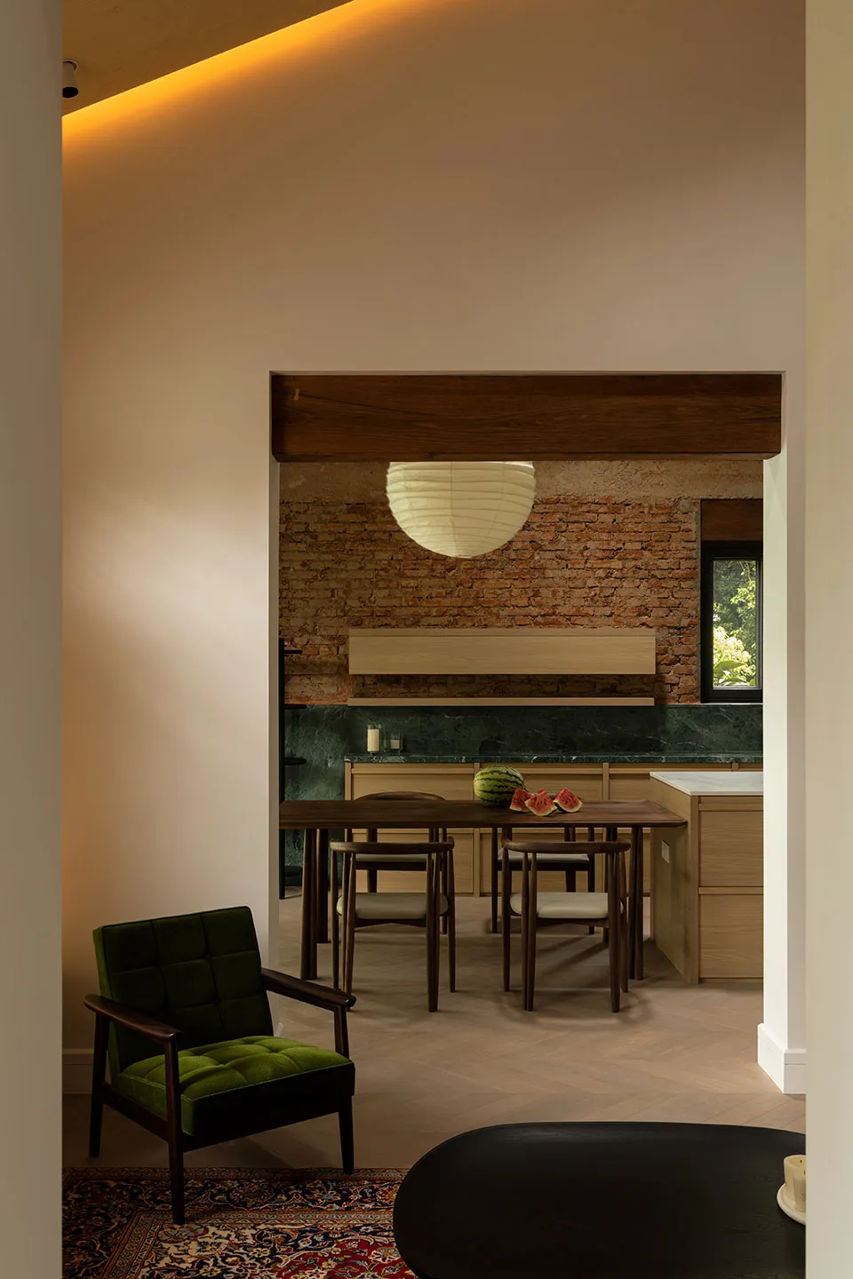 A modern kitchen dining room with wooden furniture, brick walls, and marble countertops.