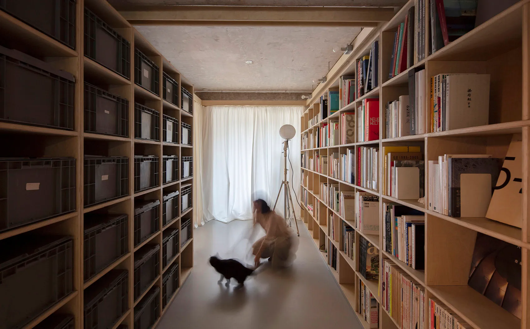 A modern library with wooden bookshelves and metal wire containers.