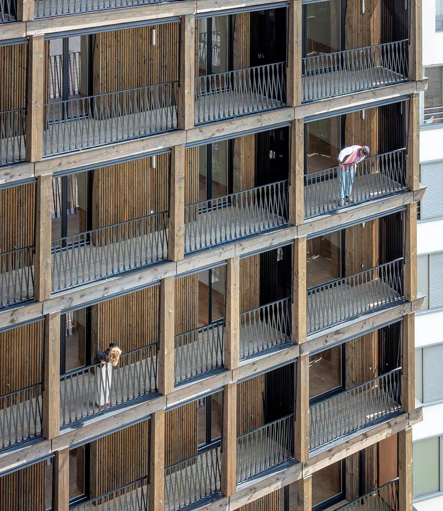 A modern residential building with wooden exterior and balconies.