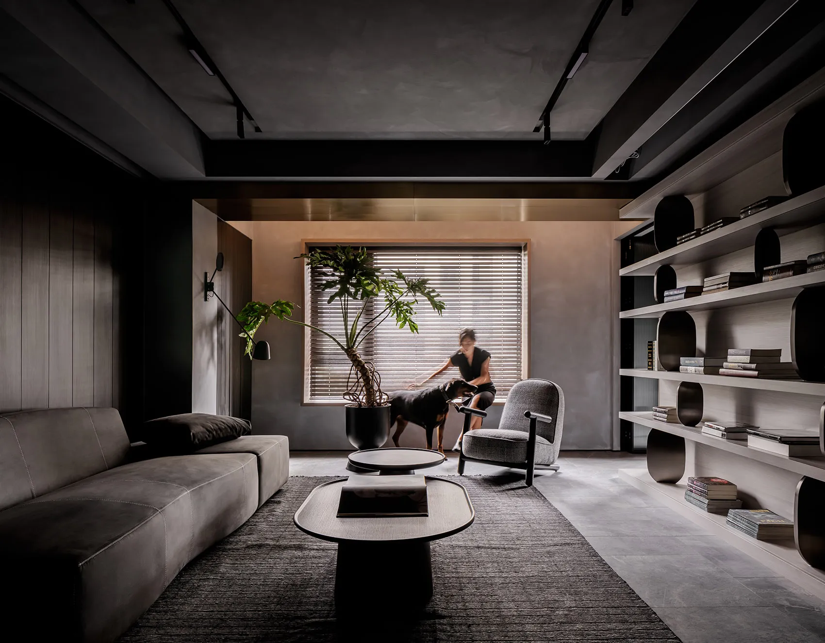 A modern living room featuring a minimalist design with concrete and metal elements.
