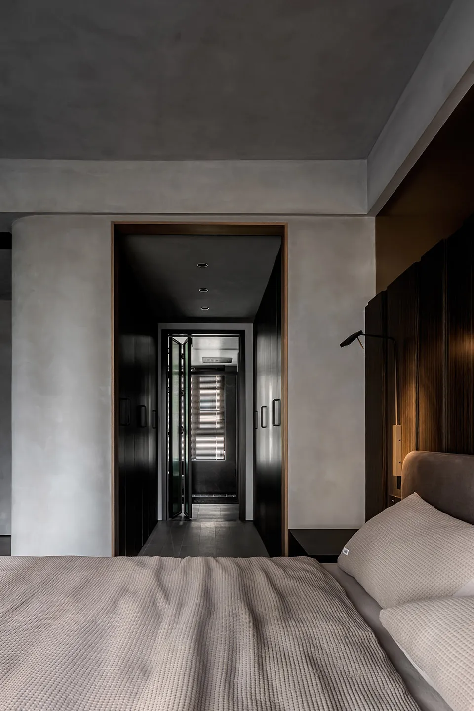Modern minimalist bedroom with a bed, nightstand, and minimal decor.