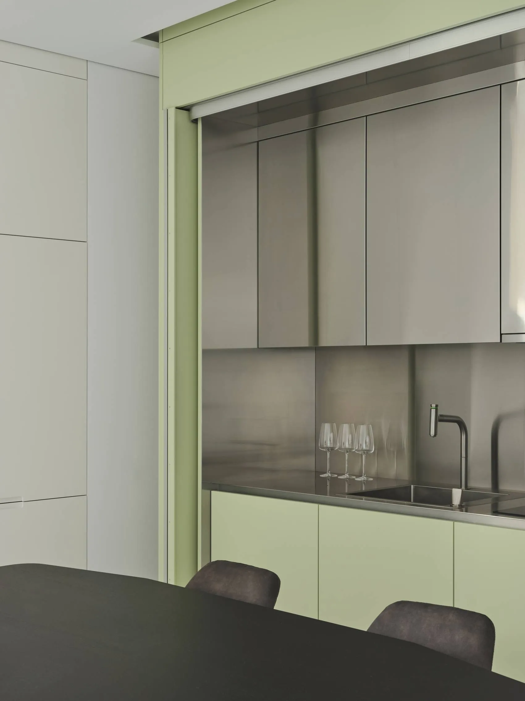 A minimalist kitchen with metallic cabinets and a sleek, modern design.