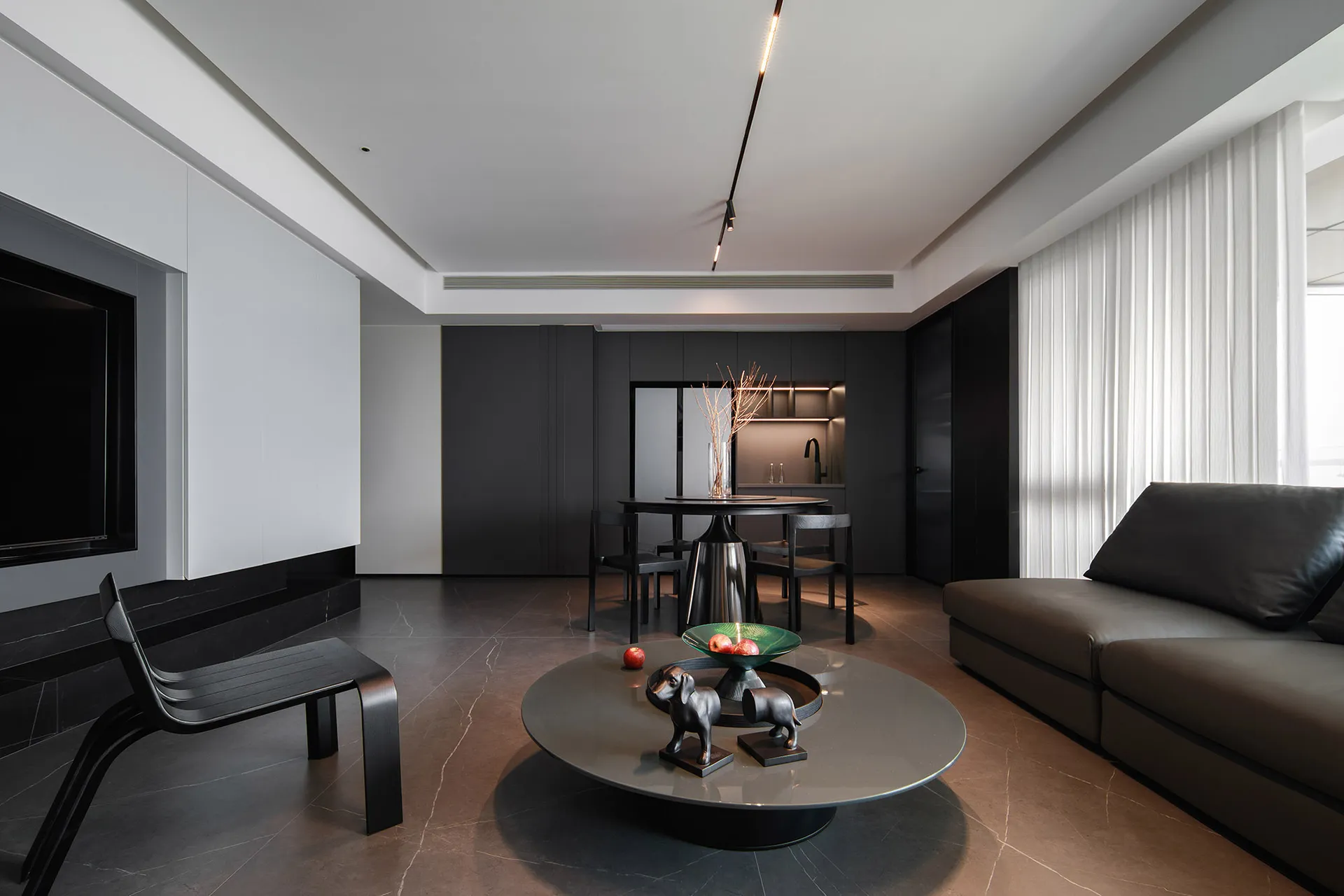 Modern apartment interior designed in black, grey, and white with a minimalist style, featuring furniture and decor that emph