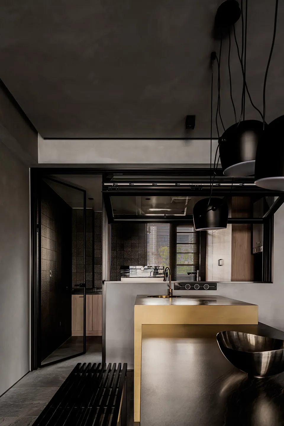 Modern minimalist kitchen featuring gray concrete surfaces and sleek black appliances.