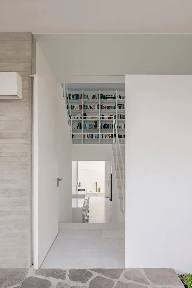 A modern interior space featuring concrete shelving filled with books.