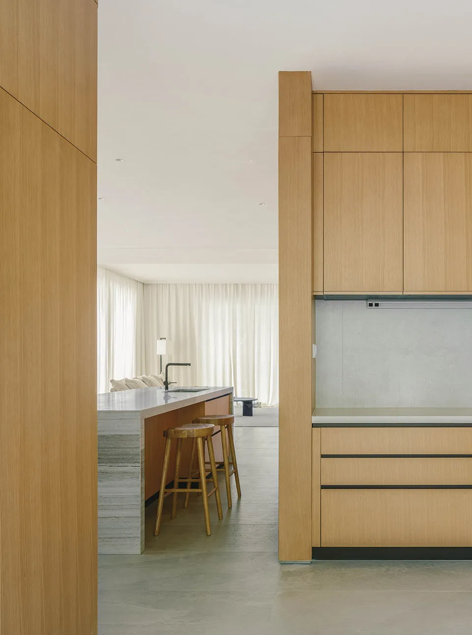 A modern kitchen interior with wooden cabinets and a marble countertop.