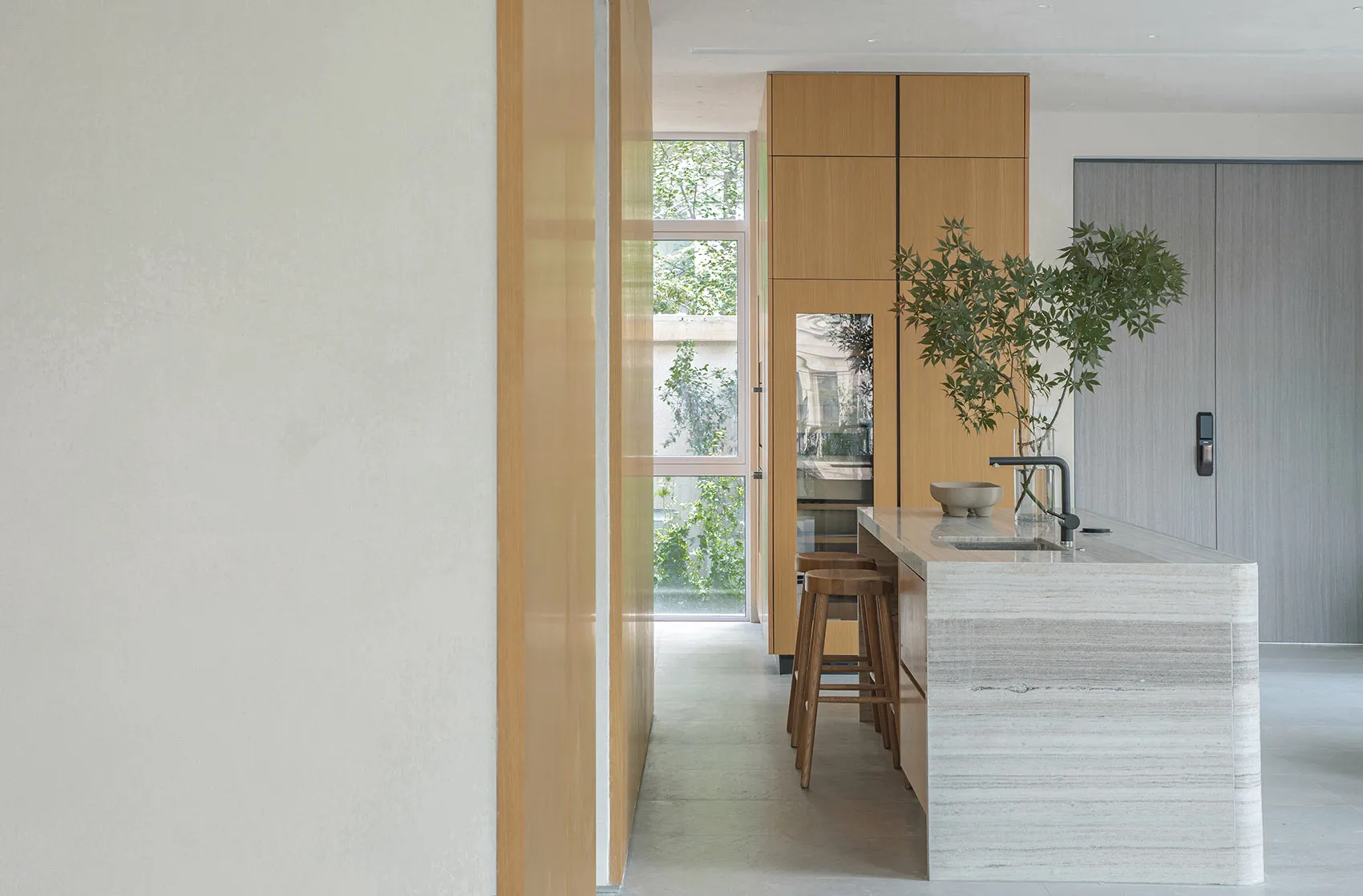 A modern kitchen with white marble countertops and wooden cabinets.