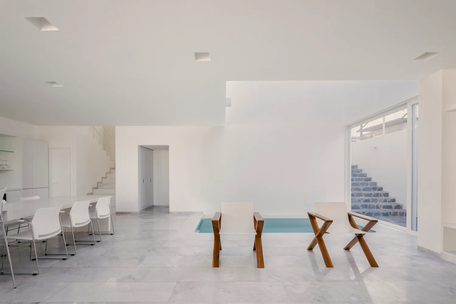 Minimalist living room with marble floor and pool area