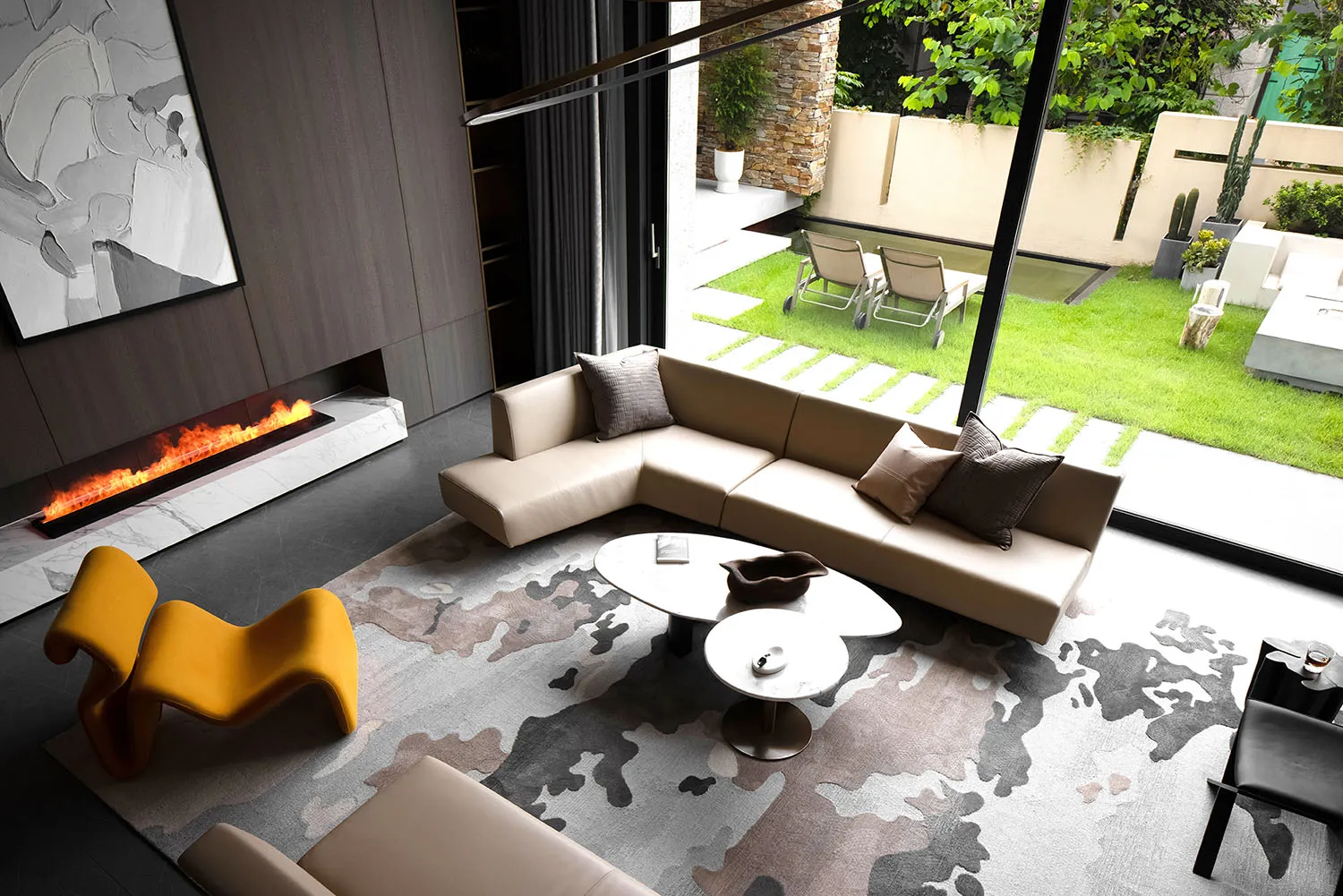 A modern living room featuring a beige sectional sofa, yellow armchair, and concrete flooring.