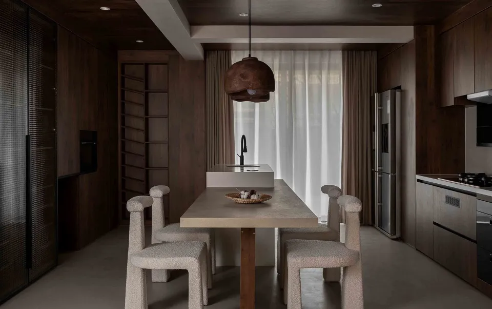 A modern kitchen with concrete countertops and wooden cabinets.