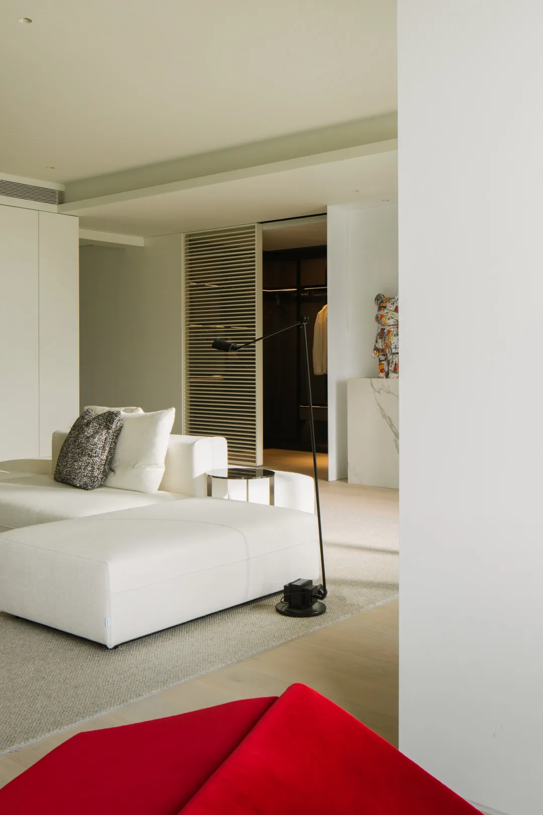 Modern minimalist living room featuring a white fabric couch, sleek floor lamp, and minimalist decor.