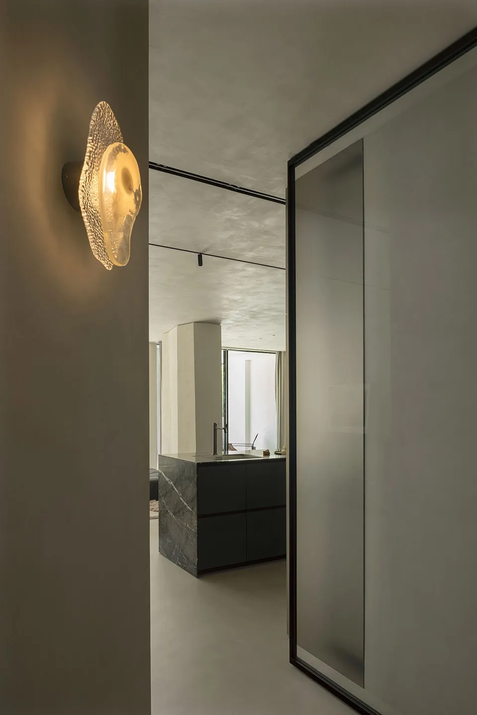 Modern minimalist house interior designed with black marble kitchen counter and glass doors.