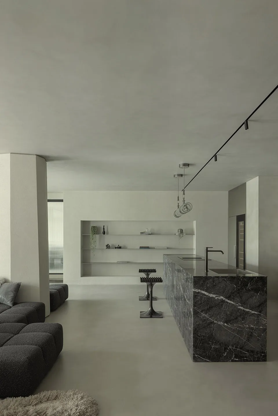A minimalist kitchen with a marble countertop and island.