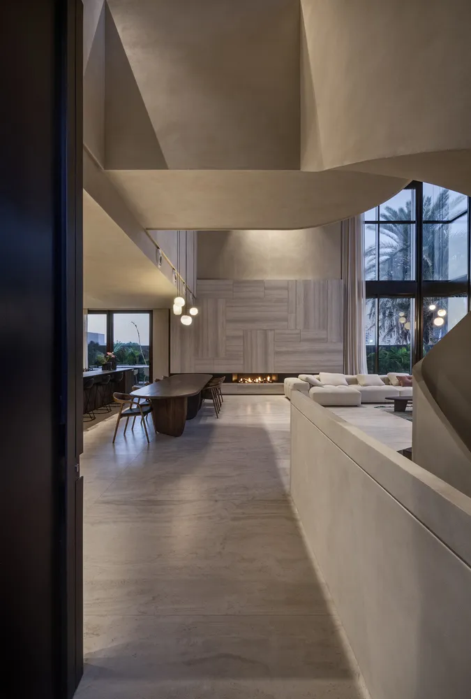 A modern living room with concrete flooring, minimalist furniture, and a fireplace.
