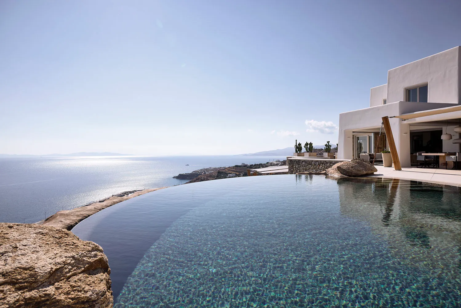 Modern vacation home overlooking the ocean with white-rendered walls, infinity pool, and sea view.