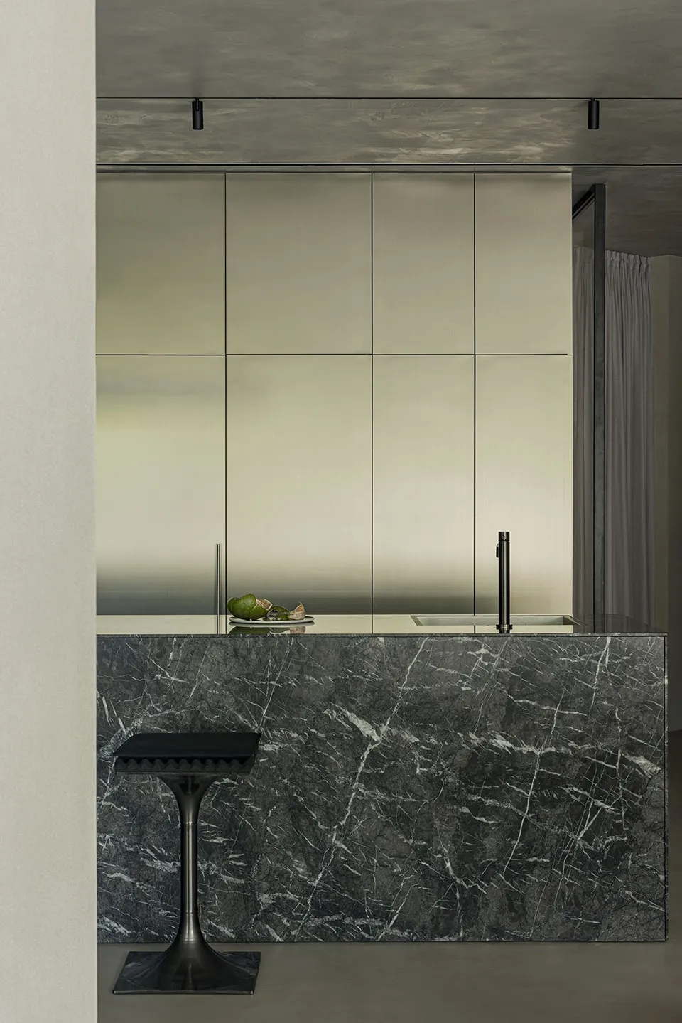 Modern kitchen featuring a sleek, minimalist design with dark marble countertops and stainless steel cabinets.
