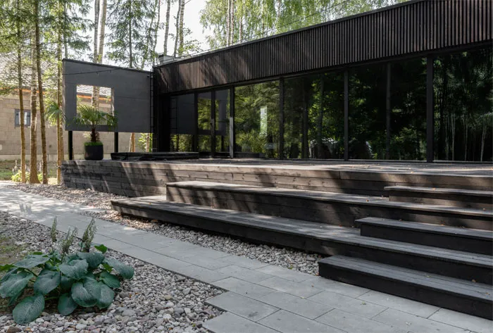 A modern residential exterior featuring a combination of wood and glass materials.