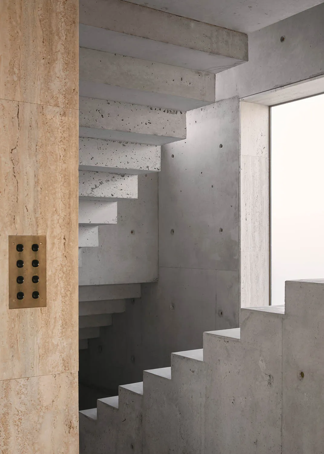 Modern concrete staircase with a window nearby