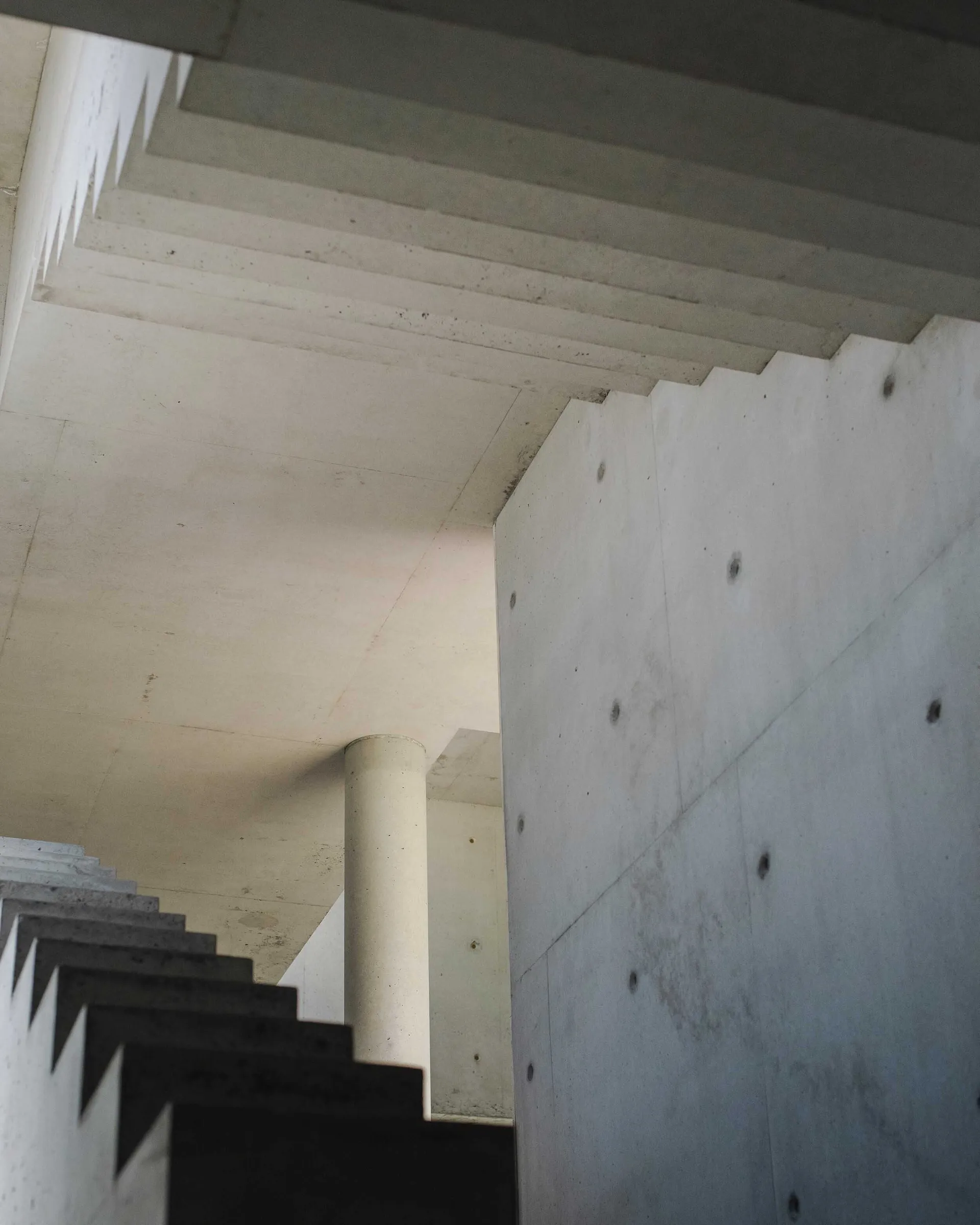 A modern industrial interior space with concrete walls and ceiling.