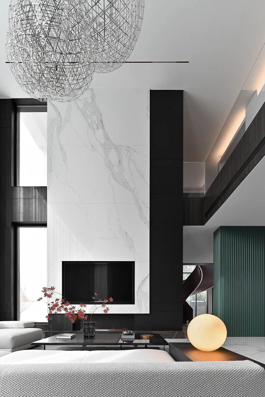 A modern living room with marble walls and a concrete fireplace.