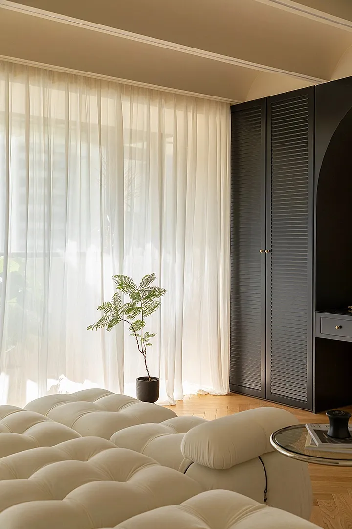 A living room with fabric curtains and wooden furniture