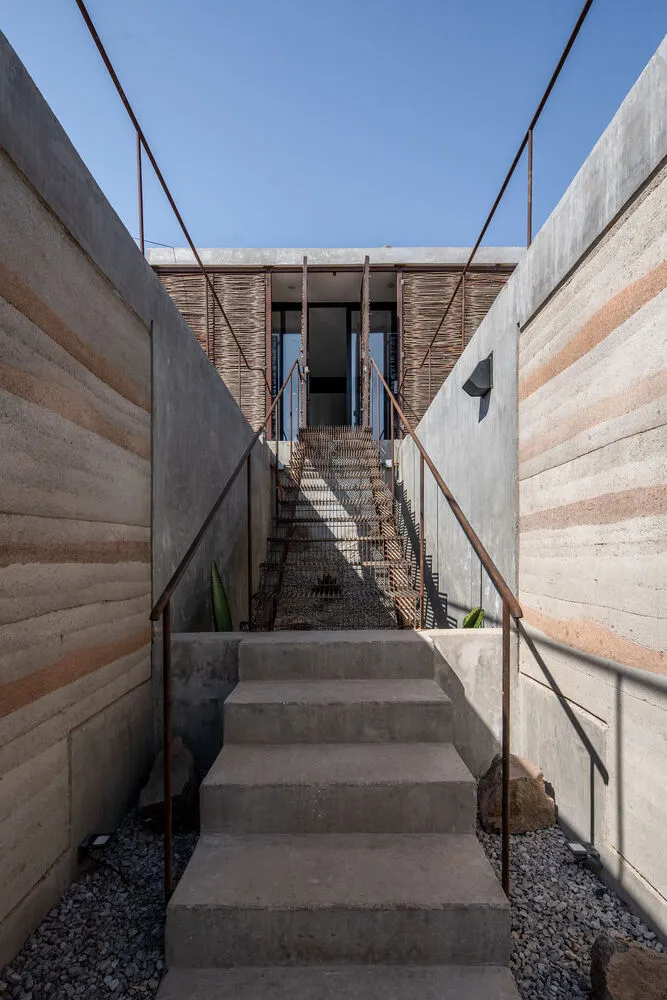 Concrete steps with wooden railings leading up to a modern building entrance.