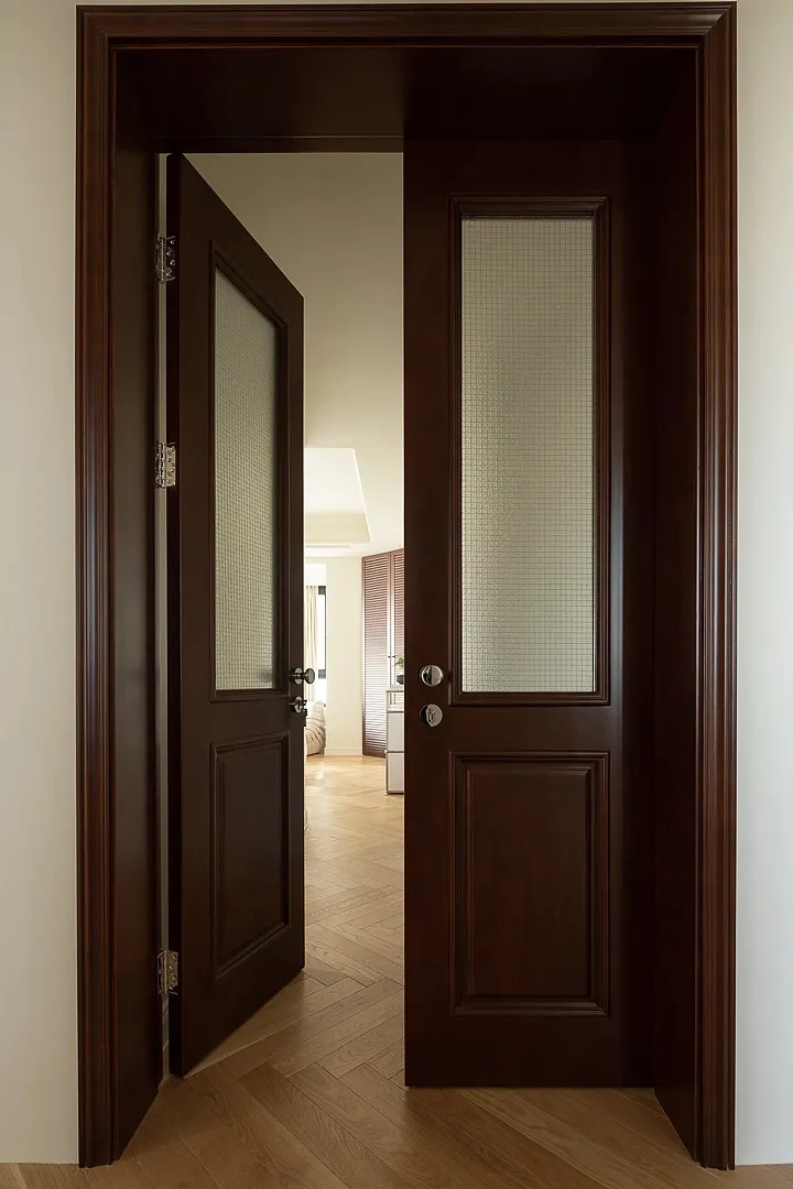 An open wooden door with glass panels leading into a residential interior.