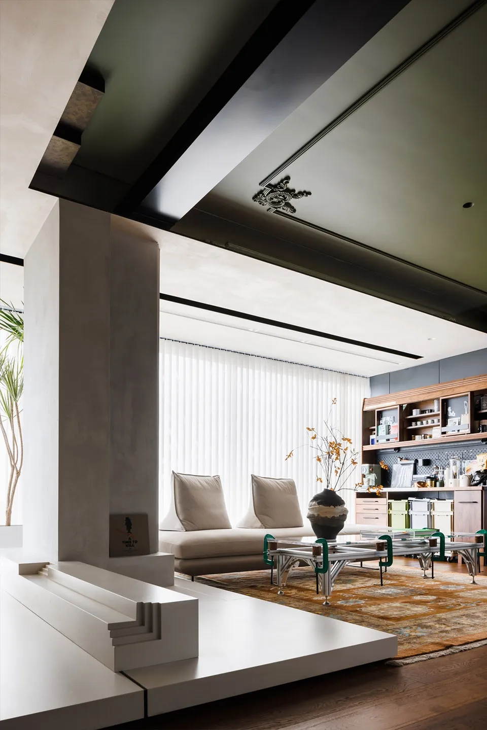 A modern living room featuring concrete and glass elements.