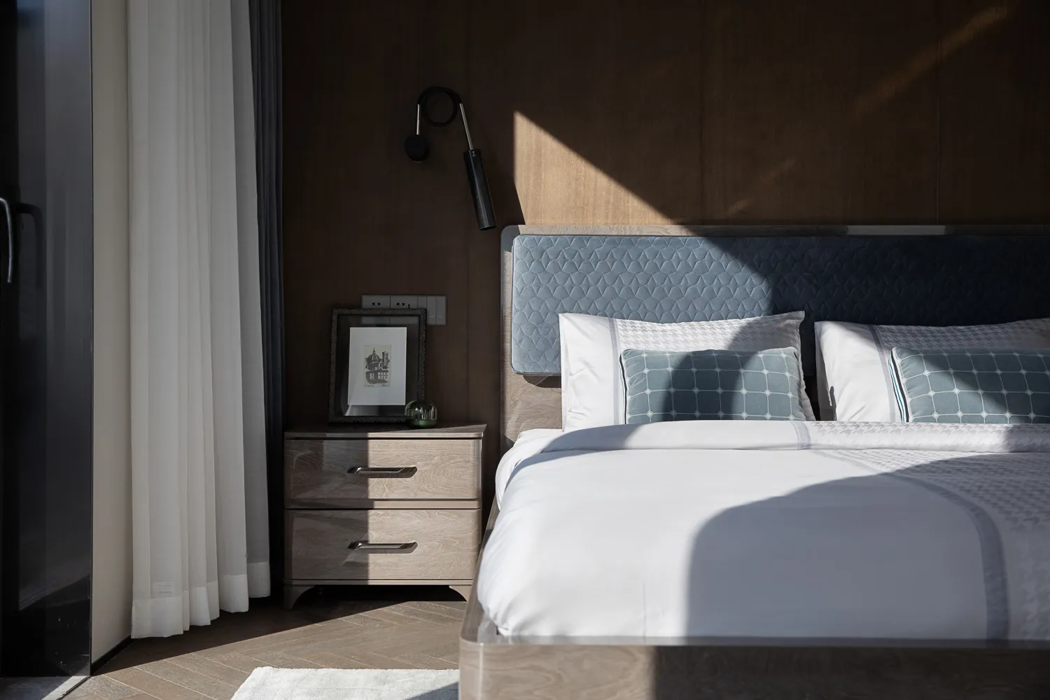 A comfortable modern bedroom with a neatly made bed, soft lighting, and minimalist decor.