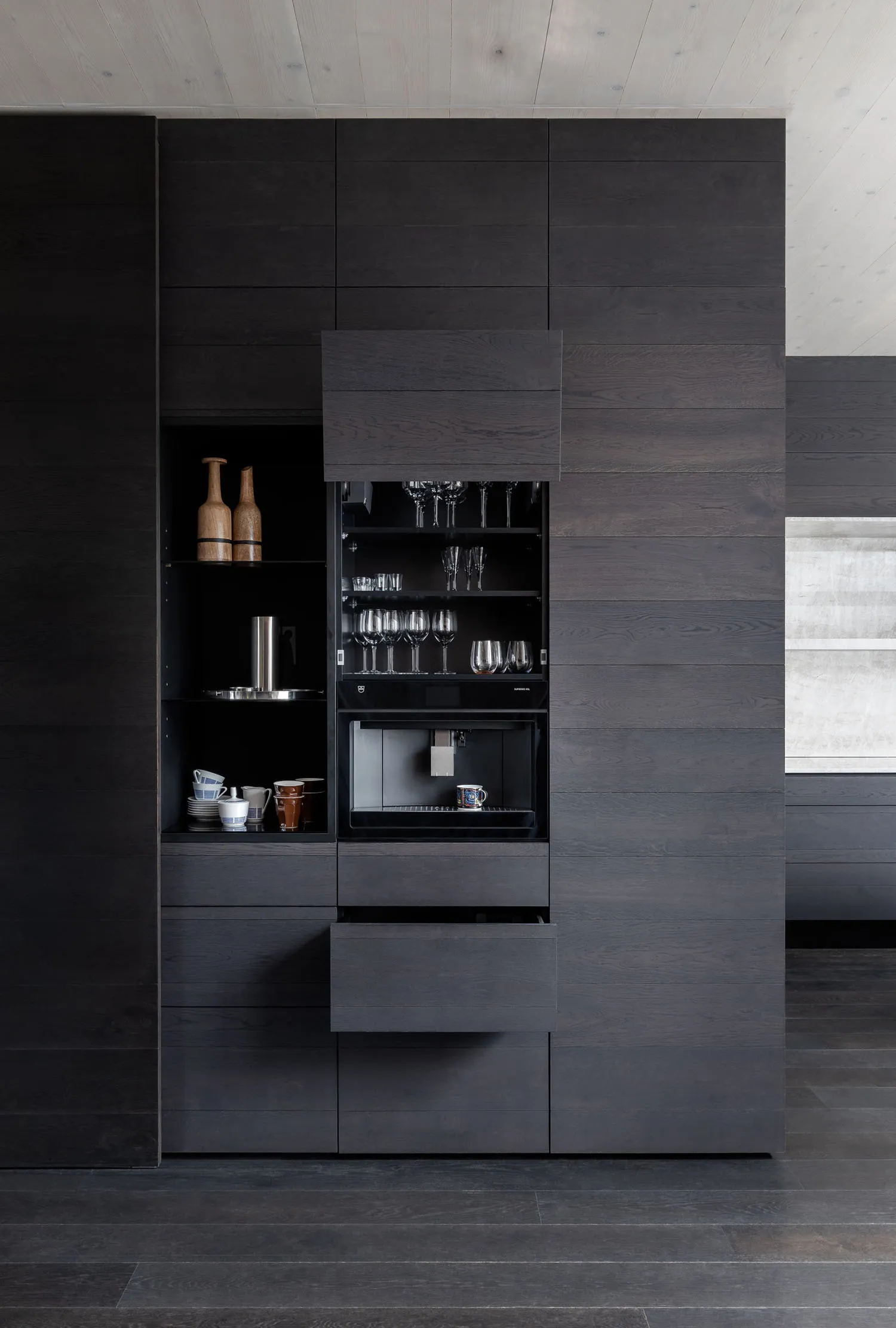 Modern kitchen with dark wood cabinets and a built-in coffee machine.
