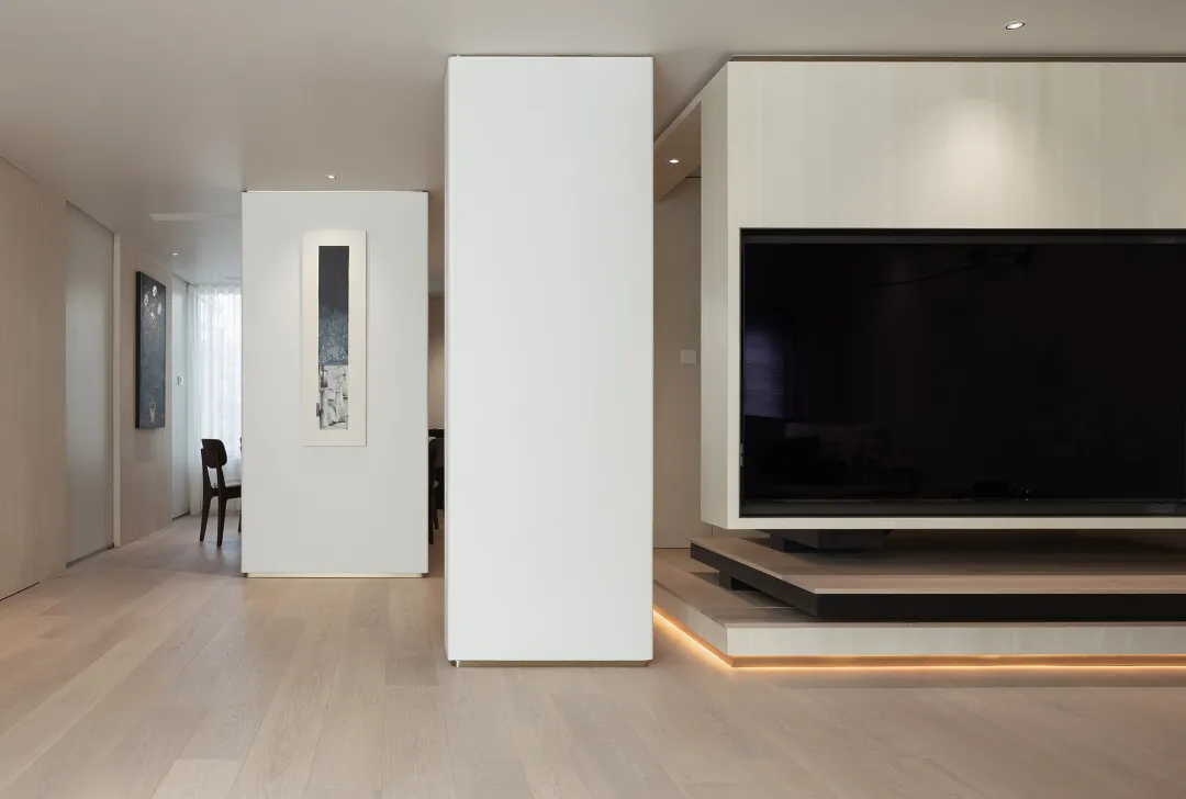 Modern living room featuring light-colored wooden floors, glass walls, and minimalist furniture.