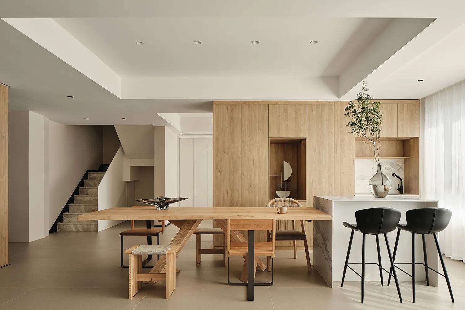 A spacious, modern kitchen with wooden furniture and a marble countertop.