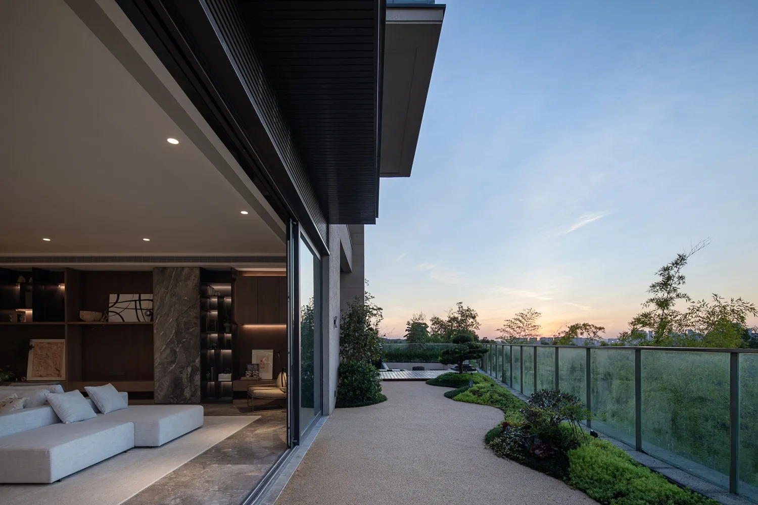 Modern residential patio featuring concrete walkway and glass railings.