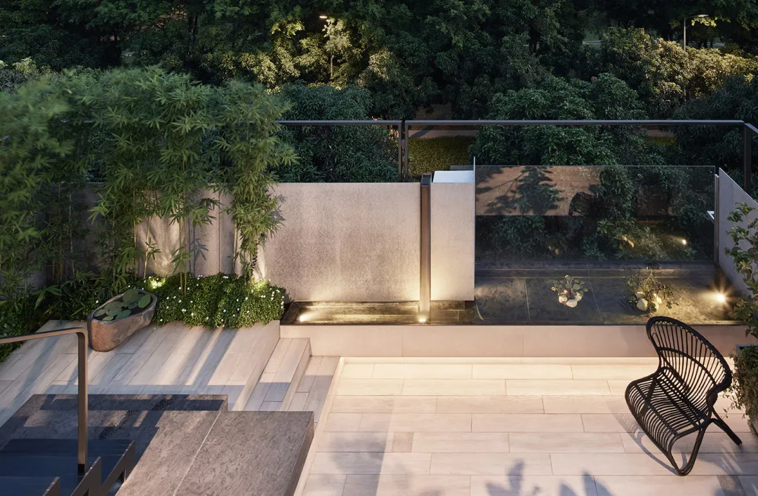 A modern rooftop garden with natural stone furniture, surrounded by lush greenery and illuminated by warm lights.