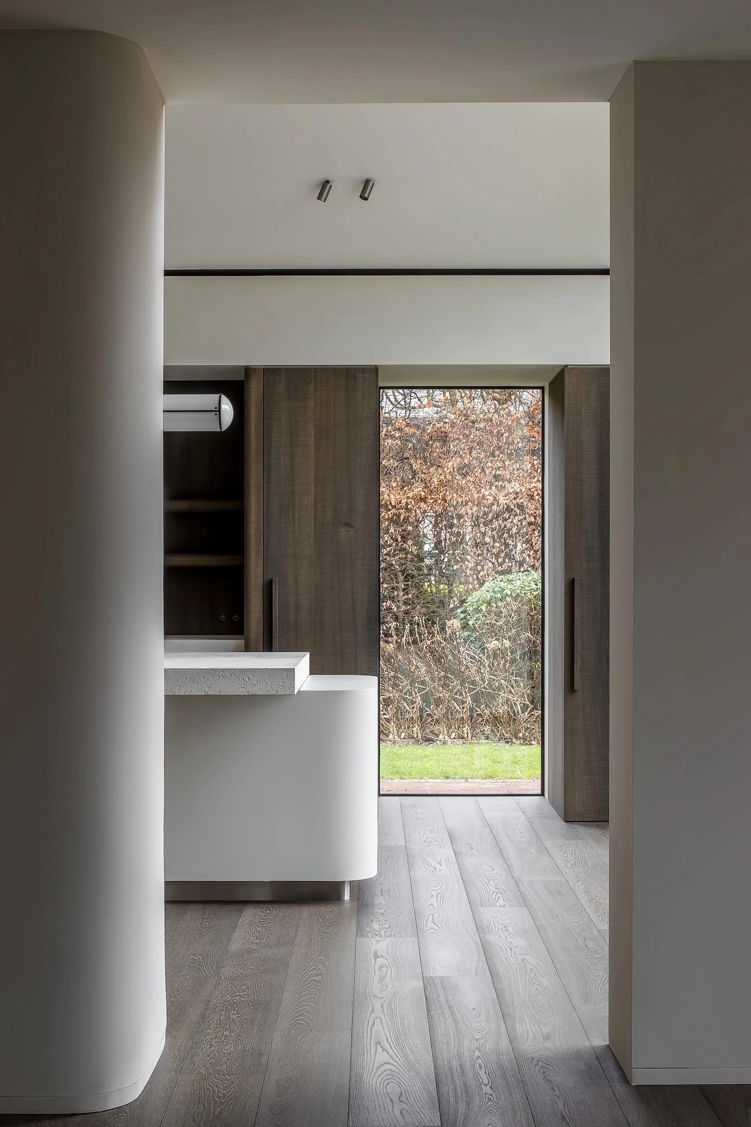 A modern residential entryway featuring wood and concrete materials, with minimalist design elements.