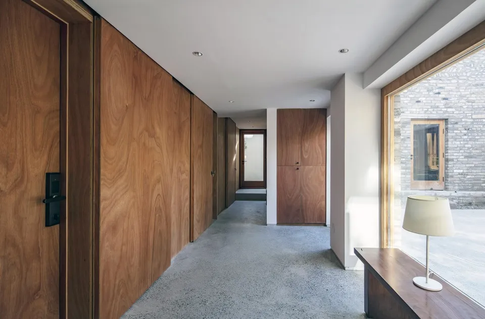 A modern hallway featuring wood paneling and a concrete floor.
