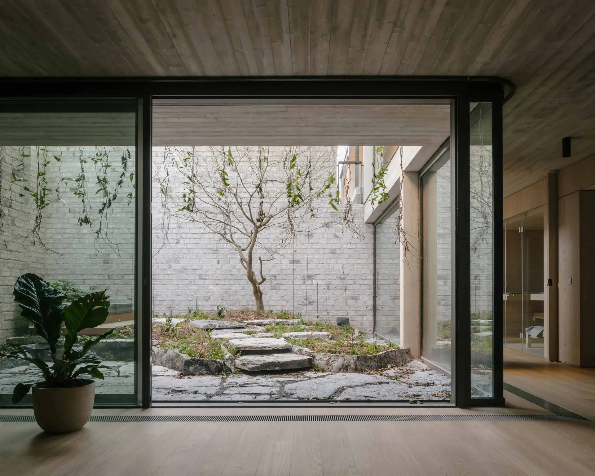 A modern minimalist residential interior featuring wooden elements and an open layout.